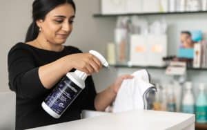 Spa professional disinfecting a towel with Prevention Ready-to-Use Spray