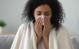 Woman with flu symptoms illustrating seasonal infection risks in salons and spas
