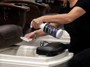 Spa professional spraying Prevention Ready-to-Use Disinfectant on a pedicure footbath