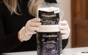 Spa professional placing a Prevention Disinfectant Wipes refill pouch into a reusable Prevention canister