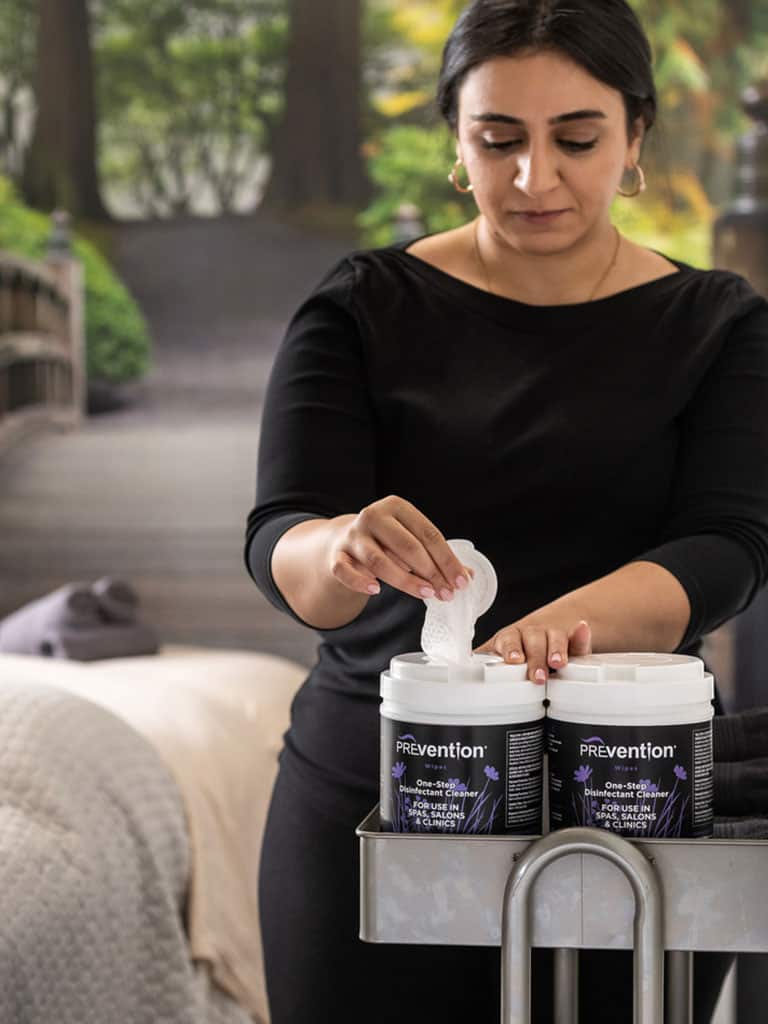 Beauty professional with Prevention Wipes on a cart